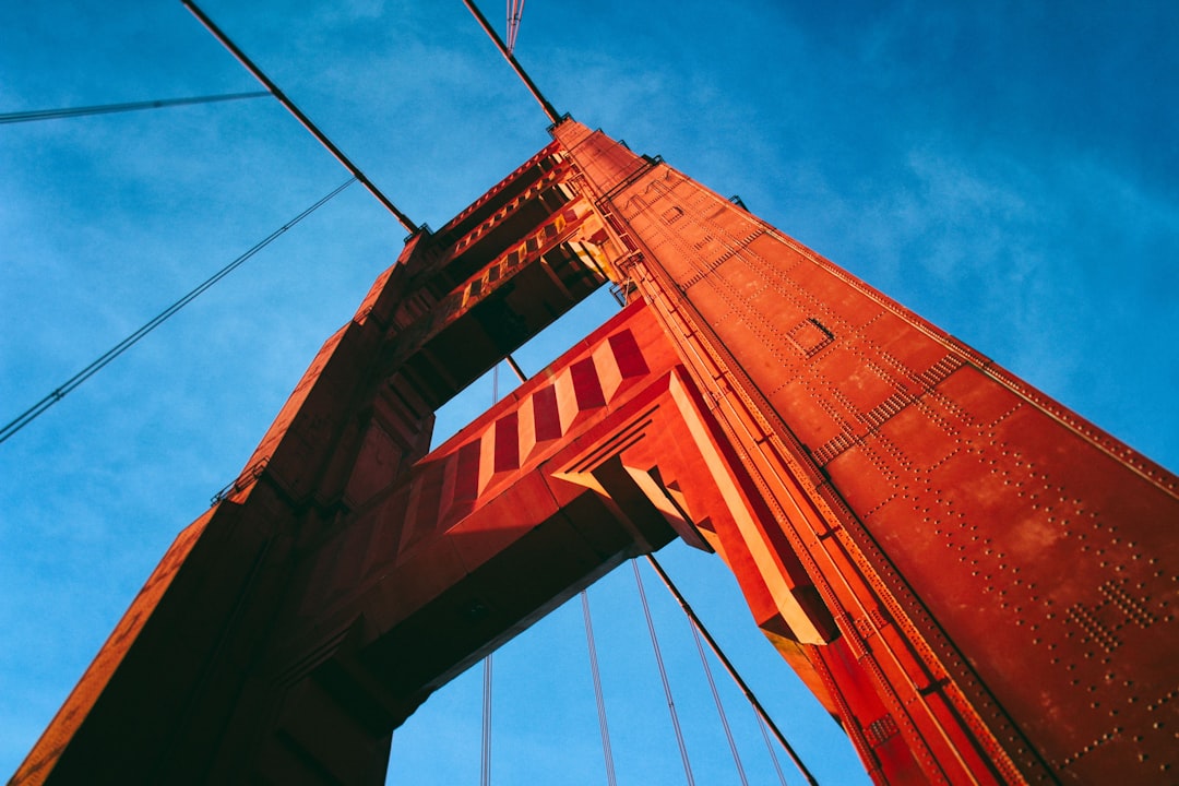 Golden Gate Bridge, San Francisco California, blue sky, golden hour, close up, lomography color negative film, red and orange tones, low angle, photo in the style of [Martin Parr](https://goo.gl/search?artist%20Martin%20Parr) –ar 128:85