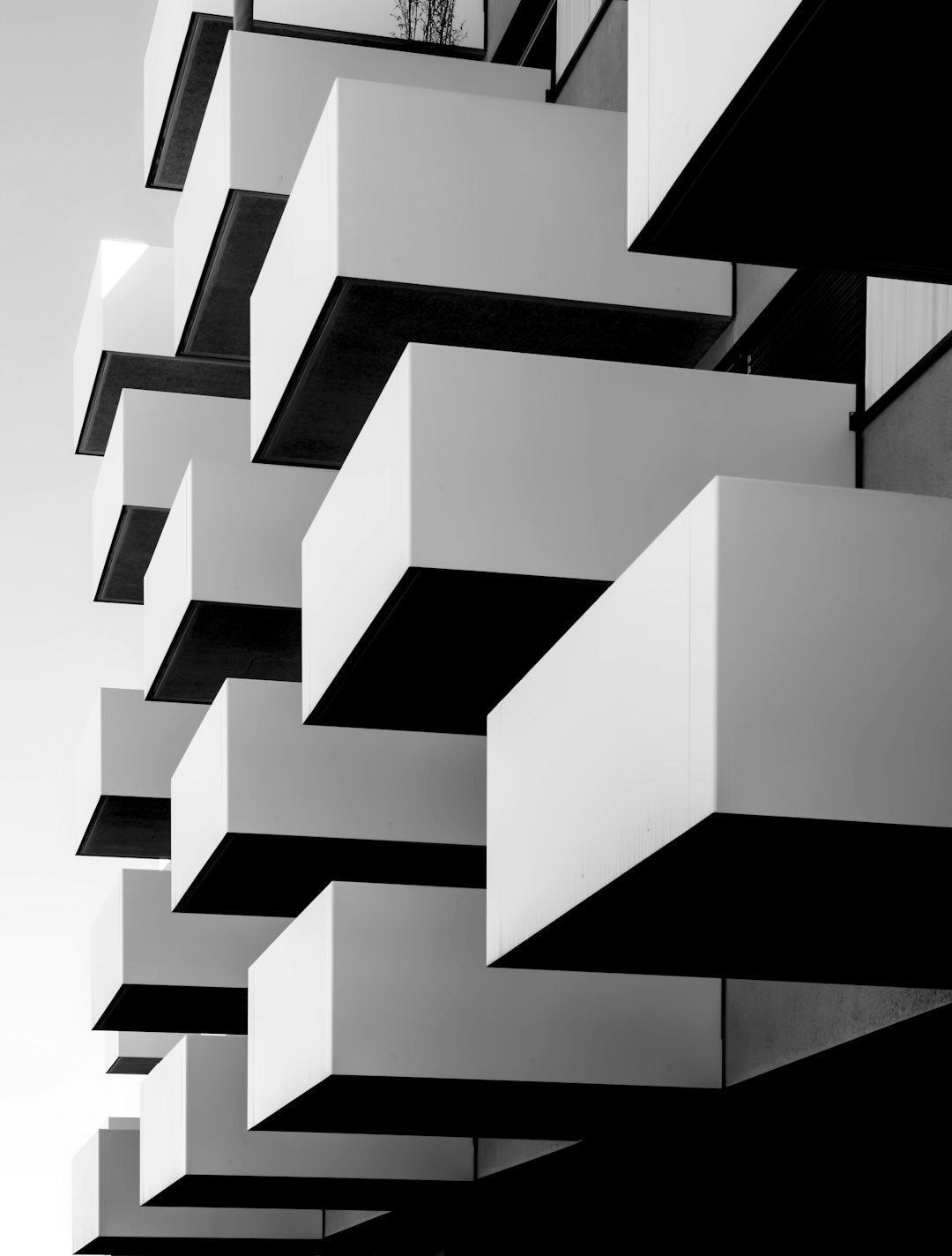 A modern building with balconies designed in the style of [Bjarke Ingels](https://goo.gl/search?artist%20Bjarke%20Ingels) group, black and white photography, minimalist style, geometric composition, architectural details, architectural design magazine award winning photo