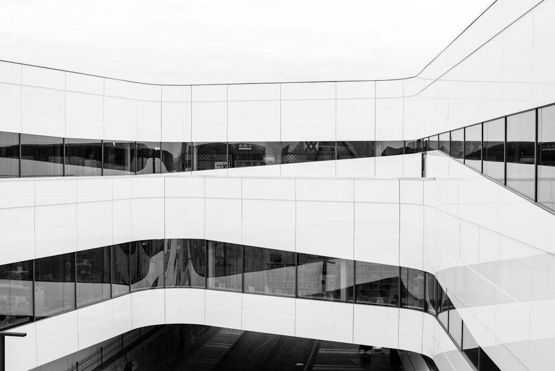 Modern white building with curved glass windows, black and white photography in the style of architectural photography, archdaily, modernism architecture. –ar 128:85