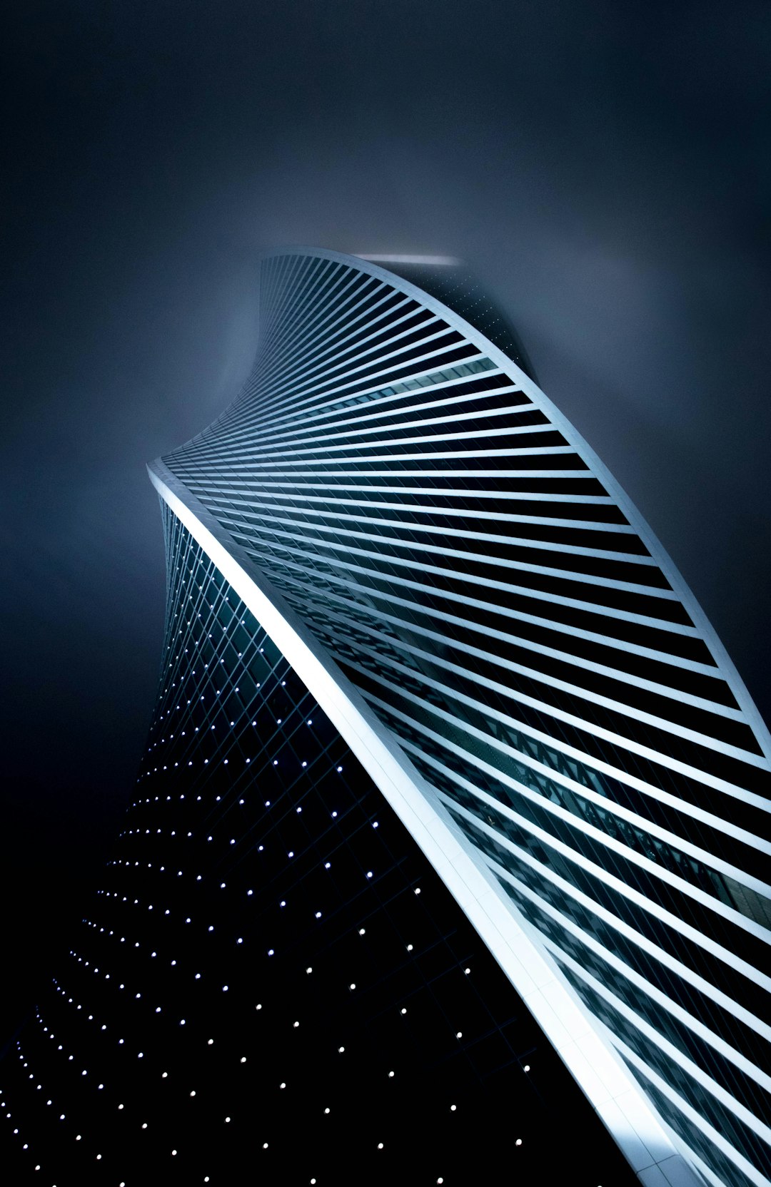 low angle photo of curved skyscraper, night sky, LED lights on building surface, minimalism, award winning photography, sharp focus, high resolution