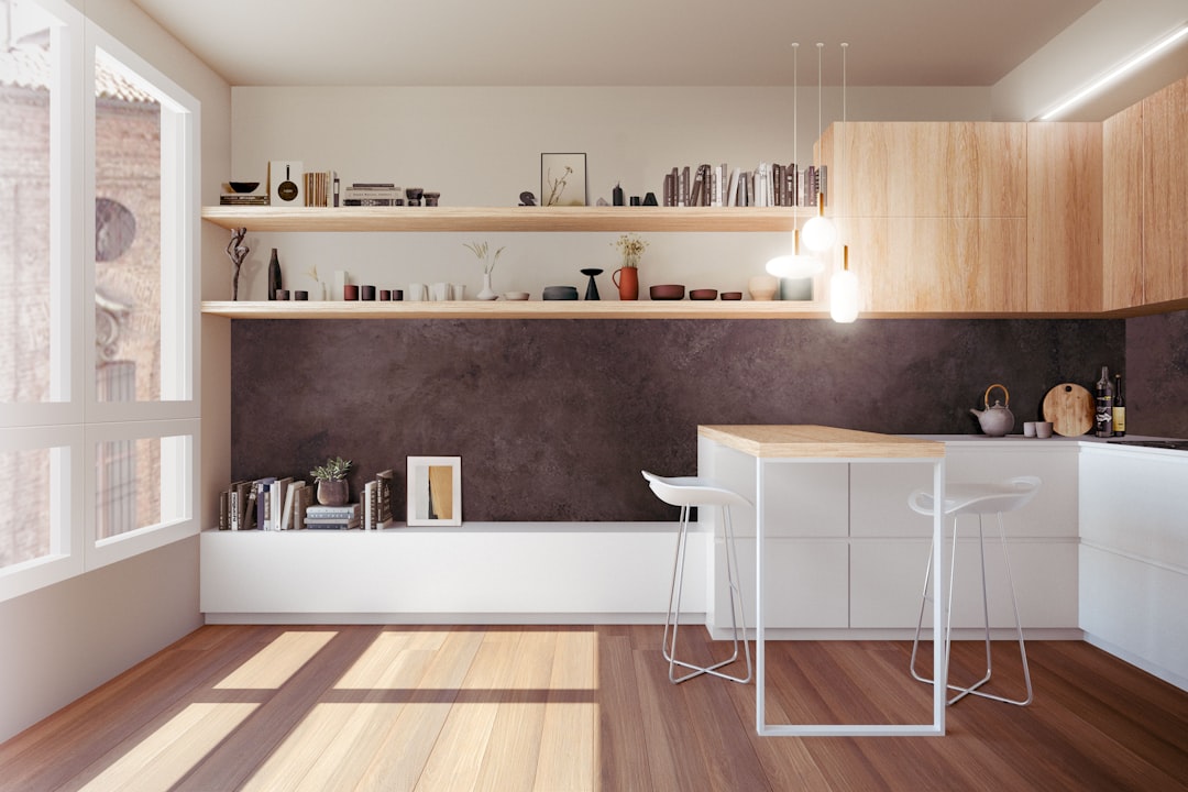 minimalist kitchen with white cabinets and wood floors, small counter table in the center of room, dark brown walls, shelves on wall above kitchen, modern art poster on one shelf, sunlight coming through window on left side of photo, architectural photography, photorealistic –ar 128:85