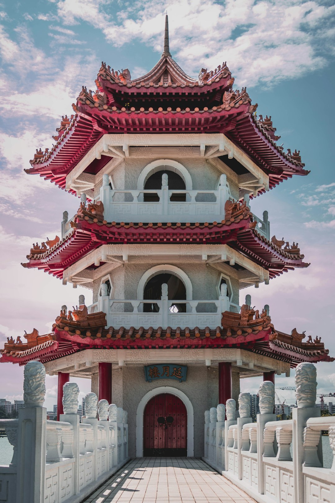 A three-story pagoda in the style of Chinese architecture, located on the top of an urban building with meticulous symmetrical architecture. The composition is symmetrical, with a sky blue background, creating a sense of grandeur and elegance. Captured from multiple angles, it showcases intricate details. High resolution photography photos with professional color grading. –ar 85:128