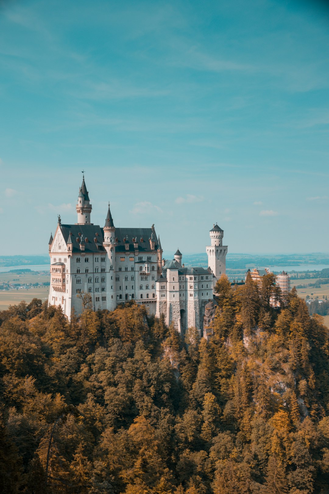 Neuschwanstein Castle in Germany, high angle shot, travel photography, summer day, blue sky, forest background, landscape photography, cinematic shot, professional color grading, soft shadows no contrast, clean sharp focus digital photography –ar 85:128