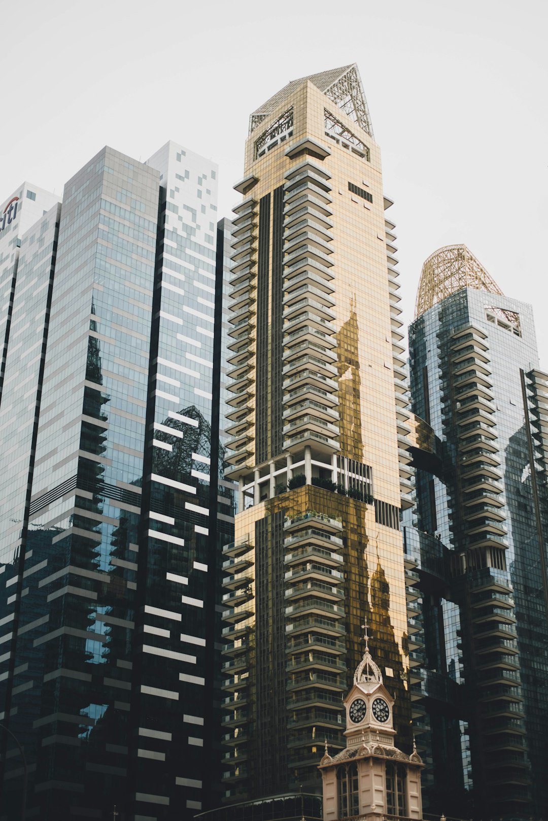 A tall building in the middle of other skyscrapers, beige and gold cityscape photography, city portraits in the style of gold and black, shot on film