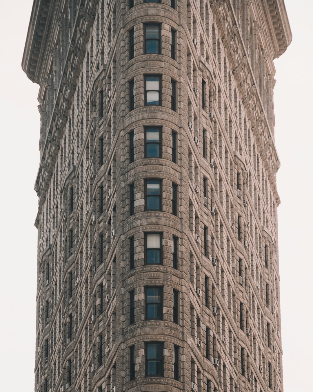 Flatiron Building, New York City, closeup shot, neutral white background, Fujifilm GFX 50S with ultrawide lens, capturing the iconic architecture and architectural details of The Flat cuales building in full frame, natural daylight, hyper realistic –ar 51:64