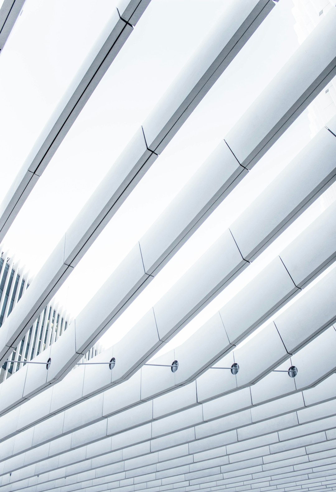 White curved roof, ceiling with white light tubes, modern architecture in a closeup horizontal composition against a bright sky with a clean background, architectural photography in high resolution