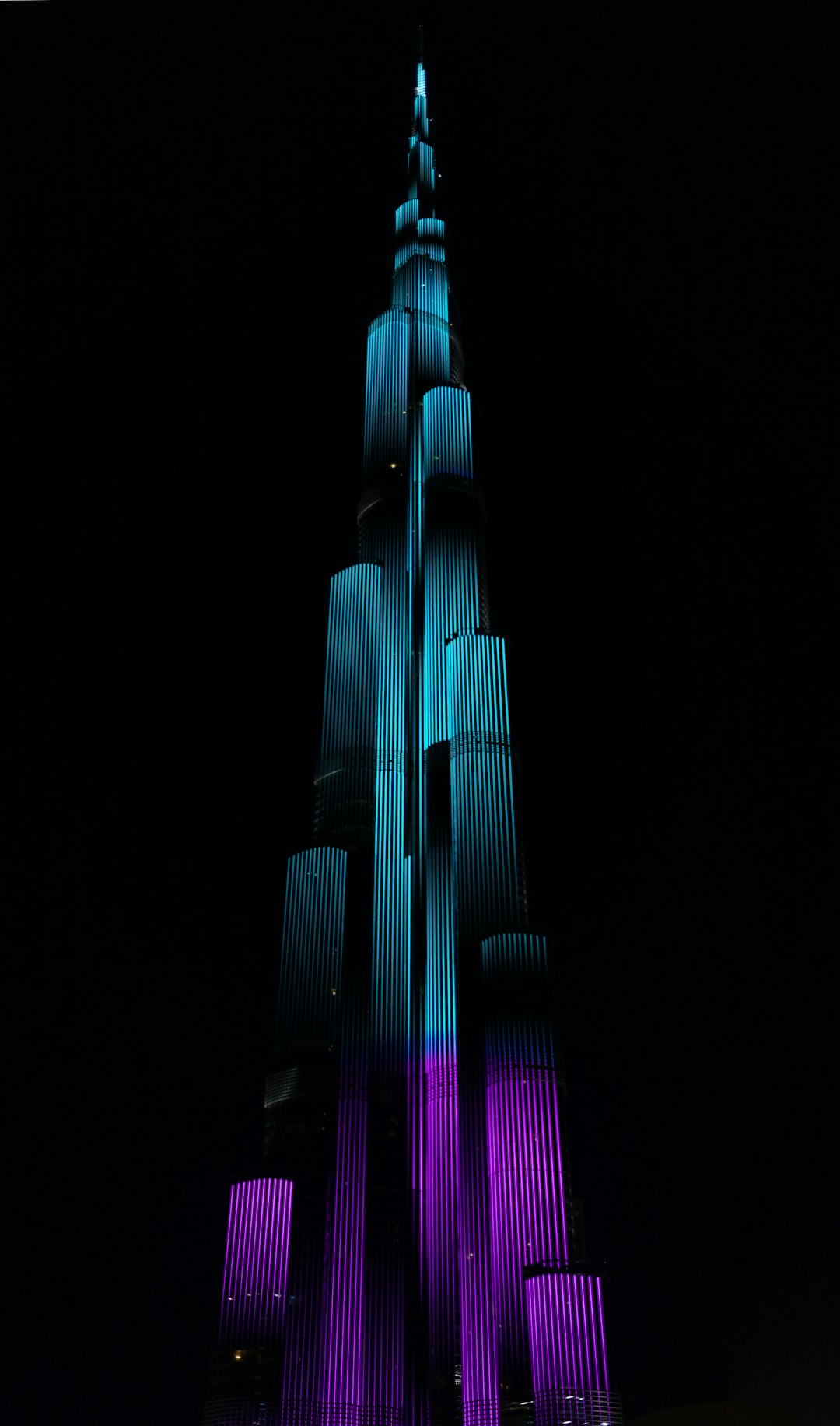 burj khalifa, illuminated in purple and blue colors, dark background, photo taken with Leica M6 –ar 75:128