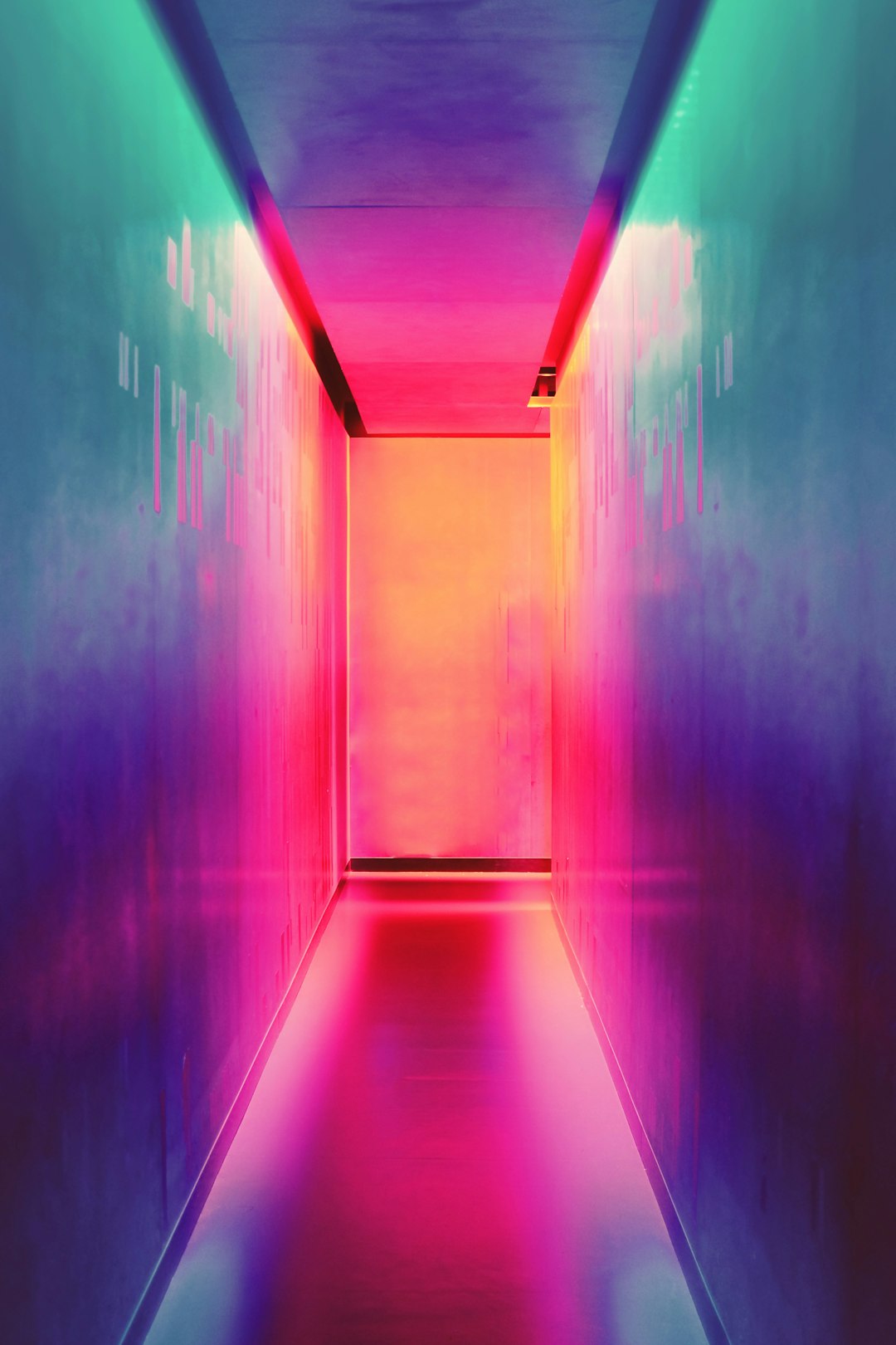 A long, narrow hallway with walls painted in vibrant neon colors, creating an atmosphere of energy and excitement. The dynamic lighting casts soft shadows on the floor, adding to its futuristic vibe. In front of you lies another door leading into another world.