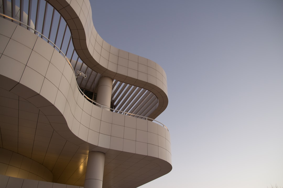 A closeup of the curved architecture of Thecup building in Los Angeles at dusk, in the style of [Jackson Pollock](https://goo.gl/search?artist%20Jackson%20Pollock) designed building. Architectural photography, archdaily, white tile and gold details, sky background, photo in the style of [Iwan Baan](https://goo.gl/search?artist%20Iwan%20Baan).