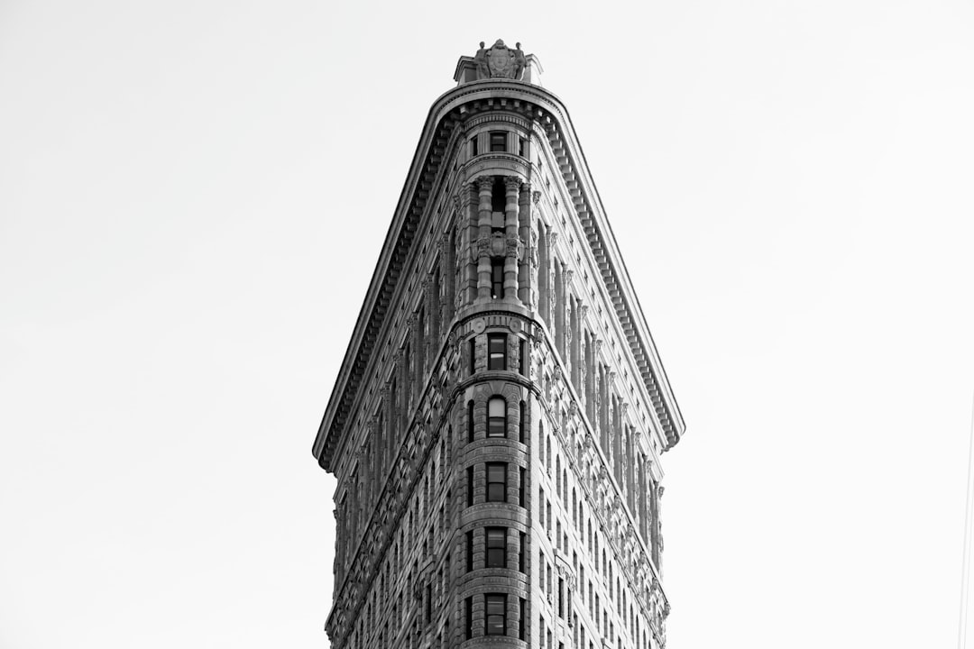 Flatiron Building, New York City, black and white photography, minimalist composition, sharp focus on the building’s shape, high resolution, captured with Nikon D850 camera using Nikon AFS NIKKOR 2470mm f/2G ED lens –ar 128:85