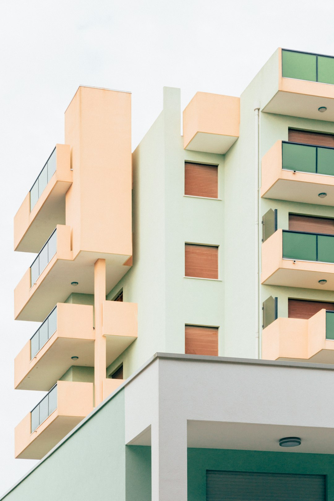 modern architecture photography, minimalistic residential building with balconies, light green and peach color scheme, architectural details in the style of minimalistic residential building with balconies, light green and peach color scheme, architectural details