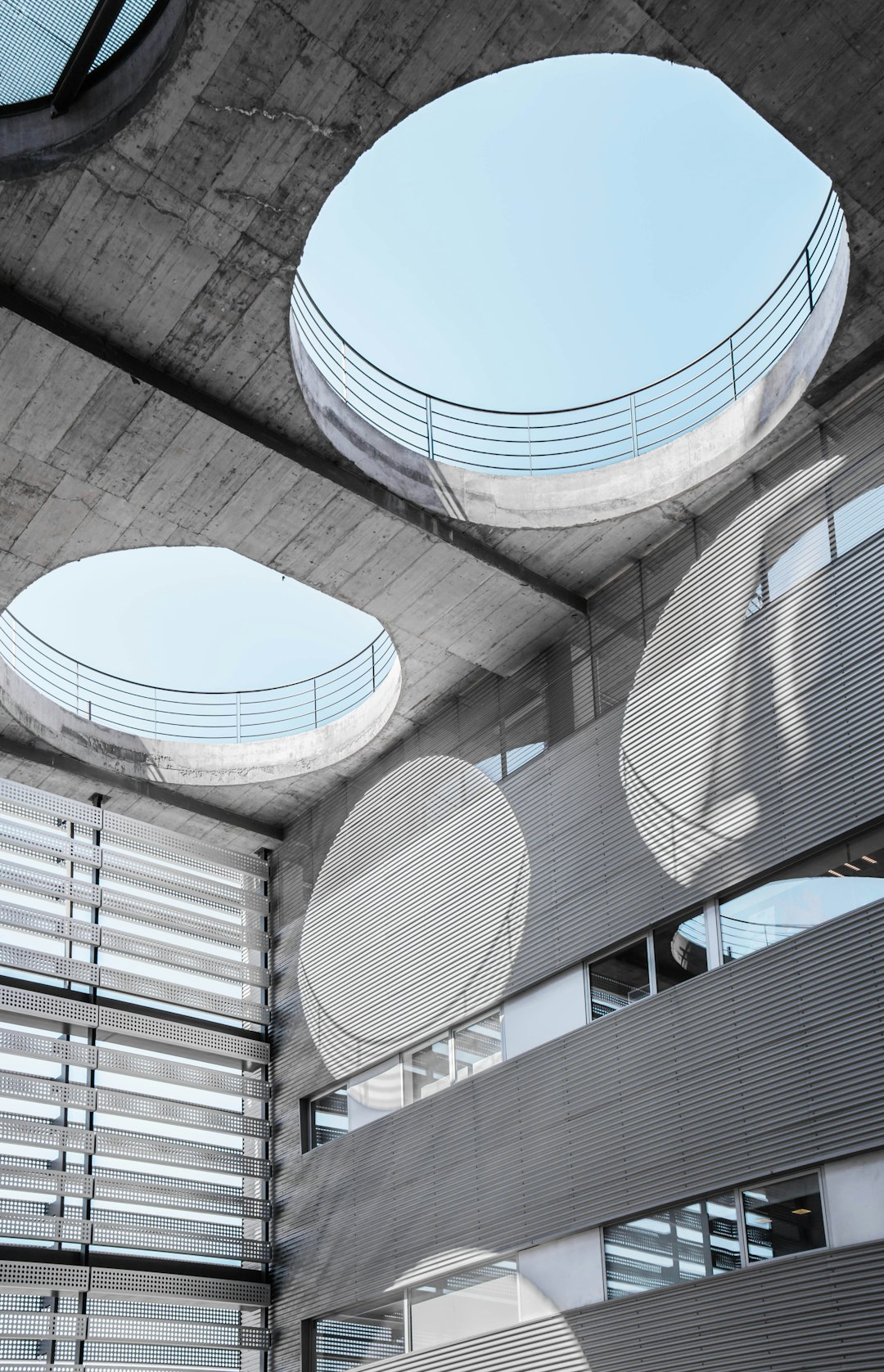 stunning shot of an architecture photography, of a concrete building with circular skylights, geometric sun screen panels, in the style of architectural design photography, light gray tones, high resolution, high details, low contrast film stock photo, taken in the style of Sony Alpha A7 IV at f/8. –ar 41:64