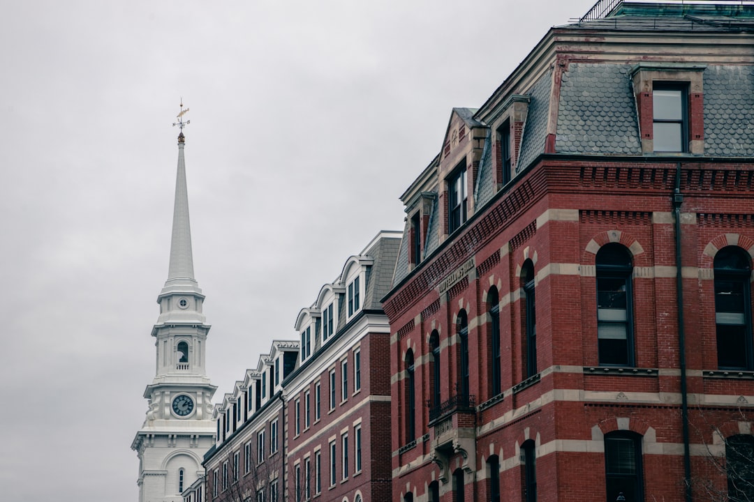 close up photo of red brick buildings with white steeple in Boston, grey sky, cloudy day, shot on canon eos r5