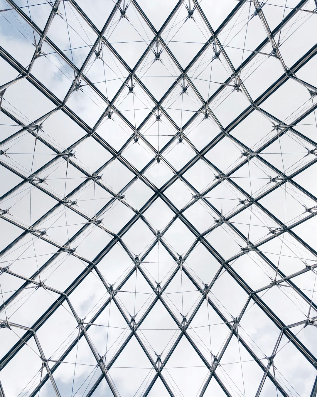 top view of glass and steel structure grid pattern of the louvre, white sky background, symmetrical composition, architectural photography, hyper realistic, –ar 51:64