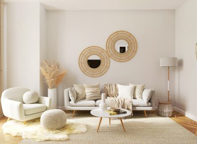 Beige living room with two round mirrors on the wall, white sofa and armchair, wooden coffee table, soft carpet flooring, and decorative elements such as pampas grass in front of them. Scandinavian interior design style.