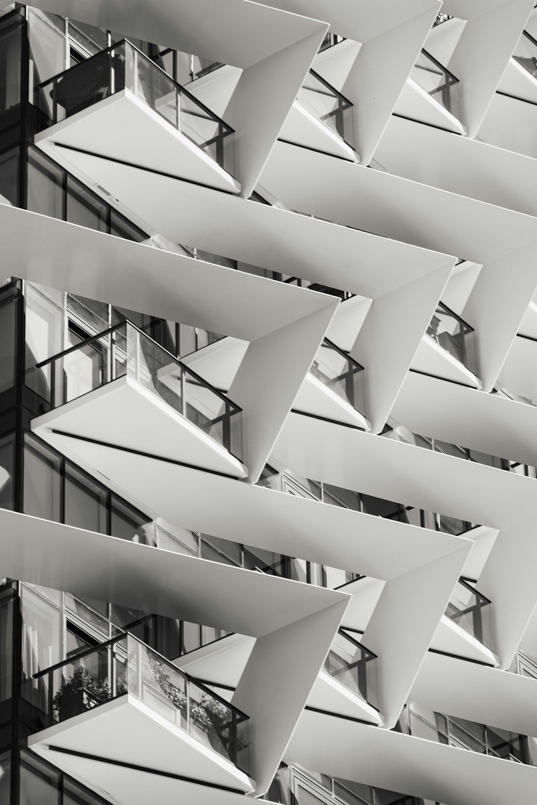 modern architecture, facade design, geometric patterned shadows, white steel details, balcony details, modern building in the city center, black and white photography, closeup, architectural magazine photo