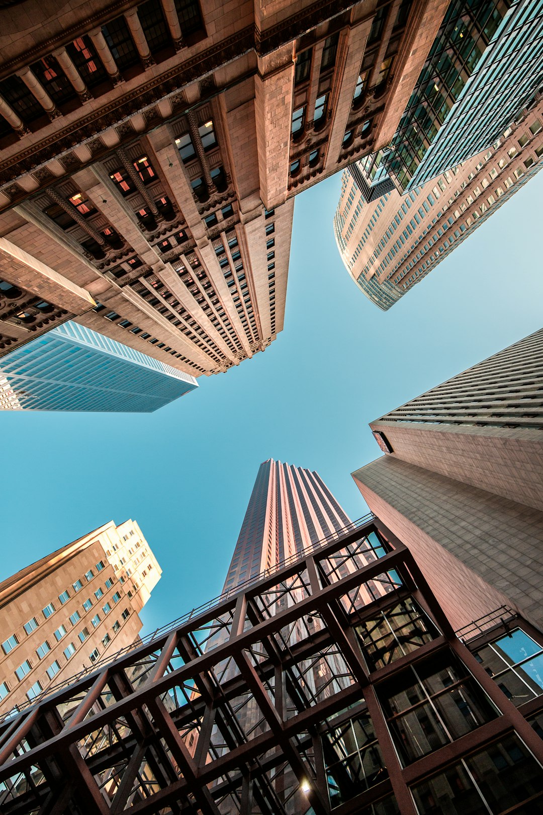 Low angle photo of tall buildings in downtown Toronto, perspective from the street looking up at skyscrapers, sky is clear blue, photo taken with Sony Alpha A7 III camera and Rokinon XG lens for high resolution. –ar 85:128