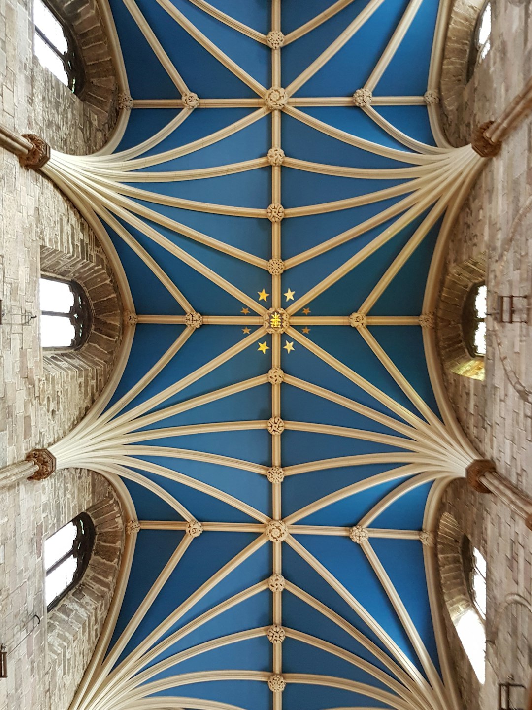 The ceiling of the great hall at Fractal Cathedral in Edinburgh was painted blue with vaulted arches and gothic architectural elements in the style of a medieval cathedral. –ar 95:128