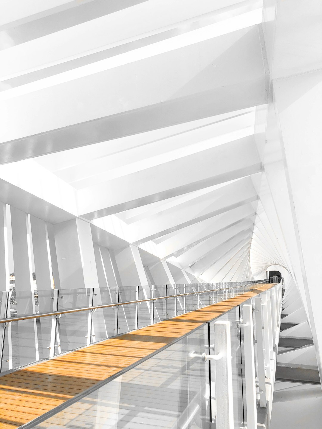 White space, interior design of a modern high rise bridge deck with glass balustrades and wooden flooring, white ceiling, perspective view, sunlight, bright light, photo taken from the side at an angle with a wideangle lens, architectural photography, architectural scene, in the style of architectural rendering, modern architecture. –ar 3:4