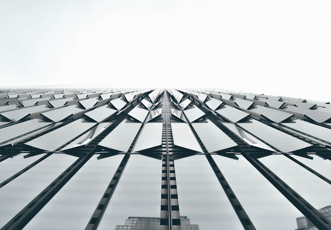 low angle photo of the facade, symmetrical composition, building made from large geometric metal shapes with sharp edges, modern architecture, minimalist design, architectural photography, archdaily, architectural grid on white background, overcast sky, grey color palette, high resolution, hyper realistic. –ar 128:89