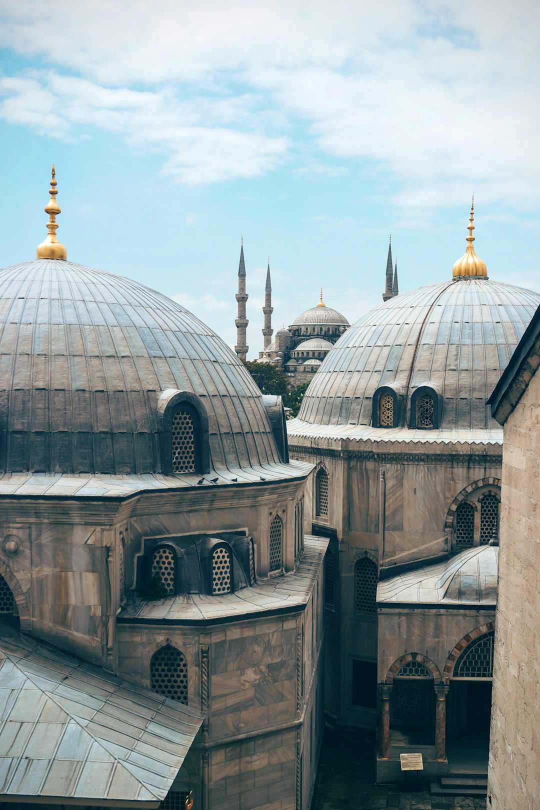 The domes of the Blue Mosque in Istanbul, with a limited color palette, in the style of architecture photography and travel photography, shot with a Sony Alpha A7 III using natural light, a blue sky, shot from above with a zoomed out bird’s eye view in clean sharp focus, with professional color grading in high resolution. –ar 85:128