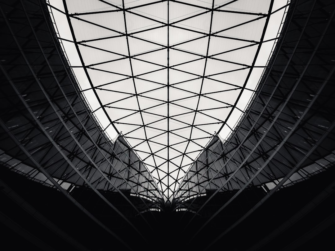 The skylight of the modern architecture, symmetrical composition with geometric shapes and symmetrical lines, geometric grid structure, black and white photography style in the style of telephoto lens, indoor environment, natural light shooting, contrast between highlights and shadows. –ar 4:3