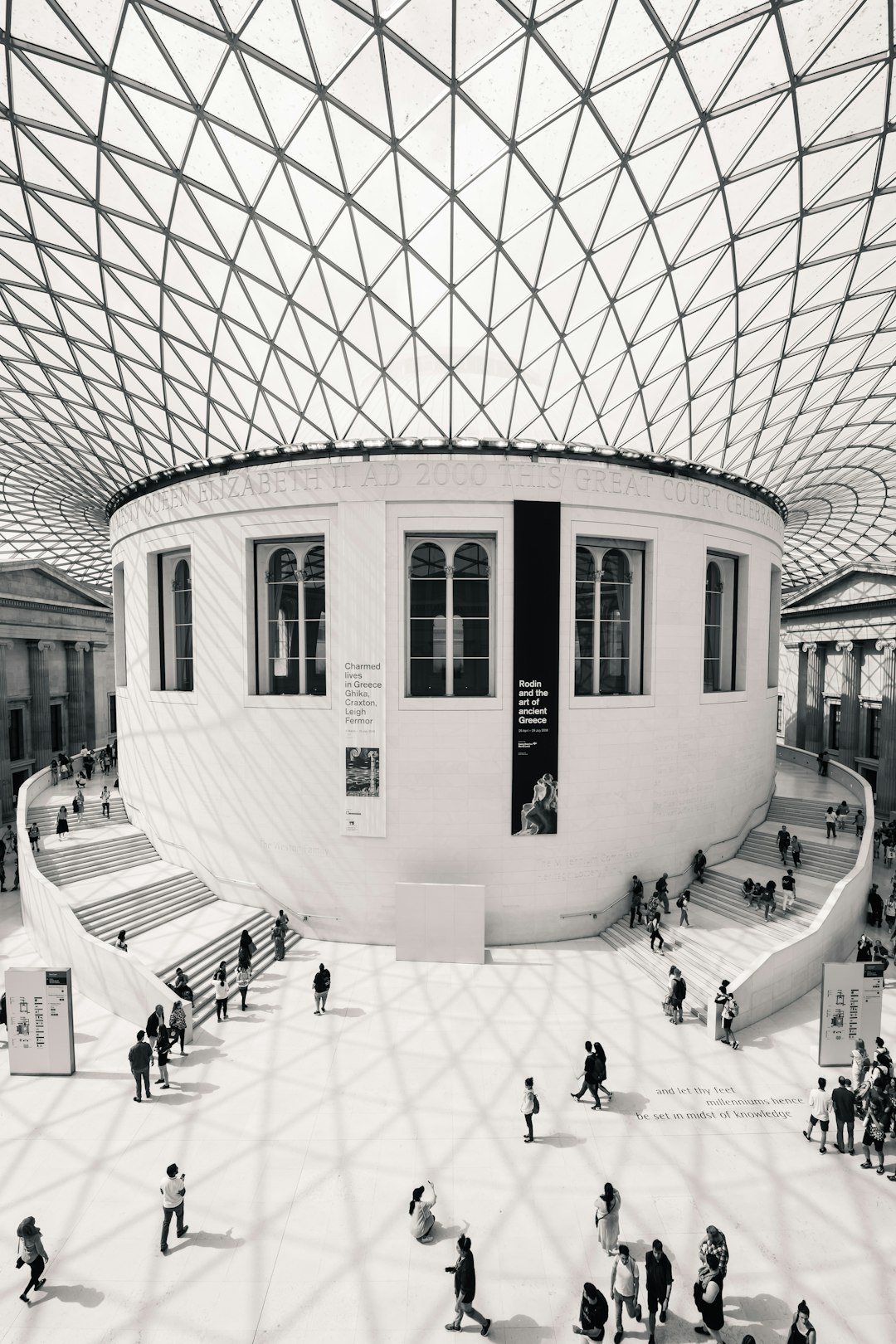 The British Museum in London, white walls and glass roof. A large circular space with people walking around the museum. Black and White photo. Minimalist style. High angle shot. Realistic photography. –ar 85:128