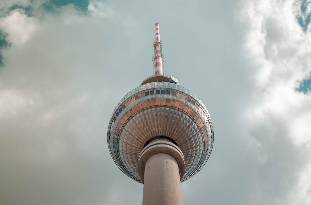 low angle photo of the Berlin TV Tower, white sky with clouds, muted colors, natural light, low contrast, low saturation, high resolution photography
