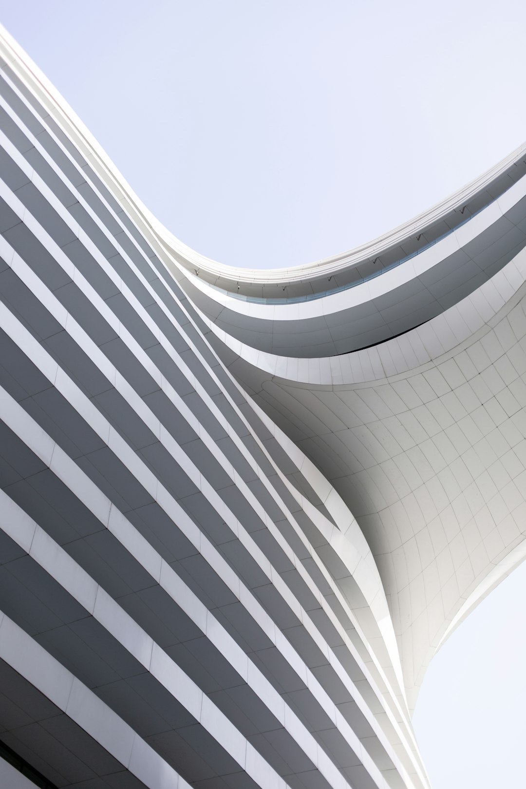 A closeup photo of the curved white metal roof with vertical stripes on an office building designed in the style of OMA in Doha, editorial photography, architectural photography. –ar 85:128