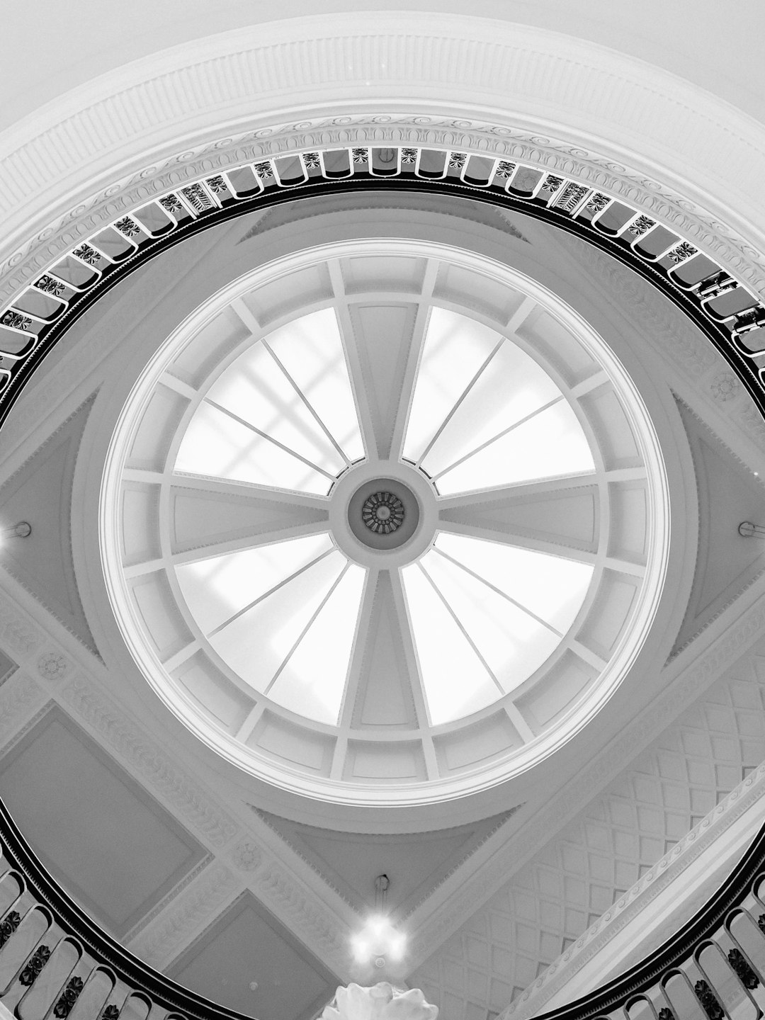 The ceiling of the stately lobby features an impressive circular skylight, framed by classical architecture and intricate details in blackandwhite photography style. The grandeur is captured with Leica M6 film camera using Kodak TriX for a timeless feel. –ar 3:4