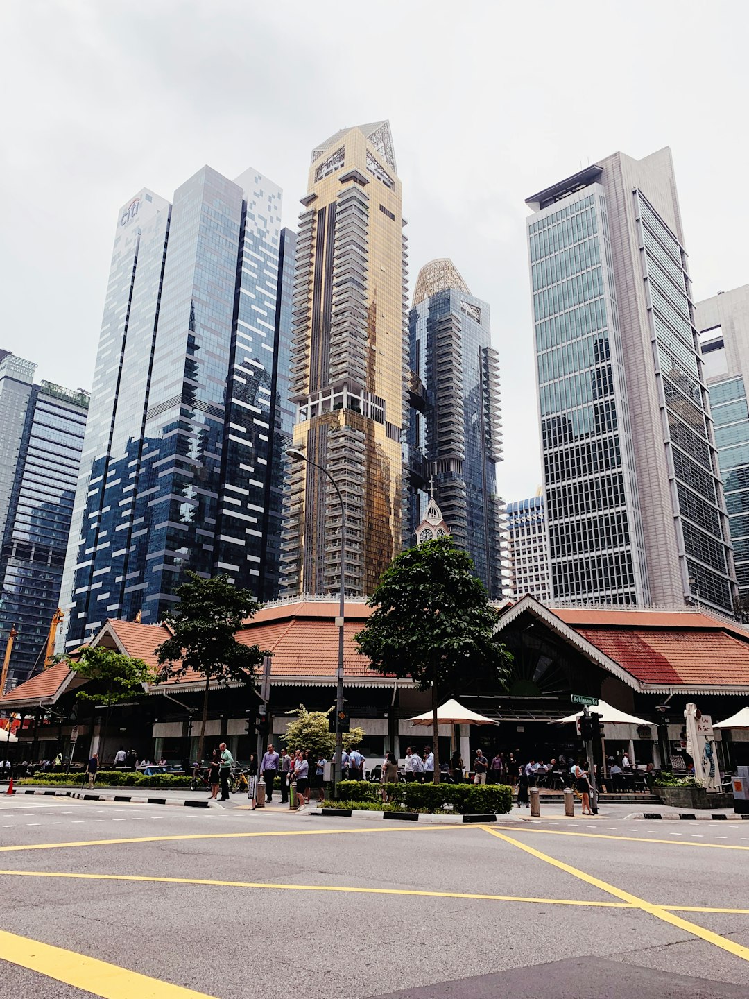 A photo of the iconic South Bridge Road market in Singapore, surrounded by skyscrapers and bustling crowds. The photograph captures its traditional architecture with modern buildings towering above it, focusing on its face.