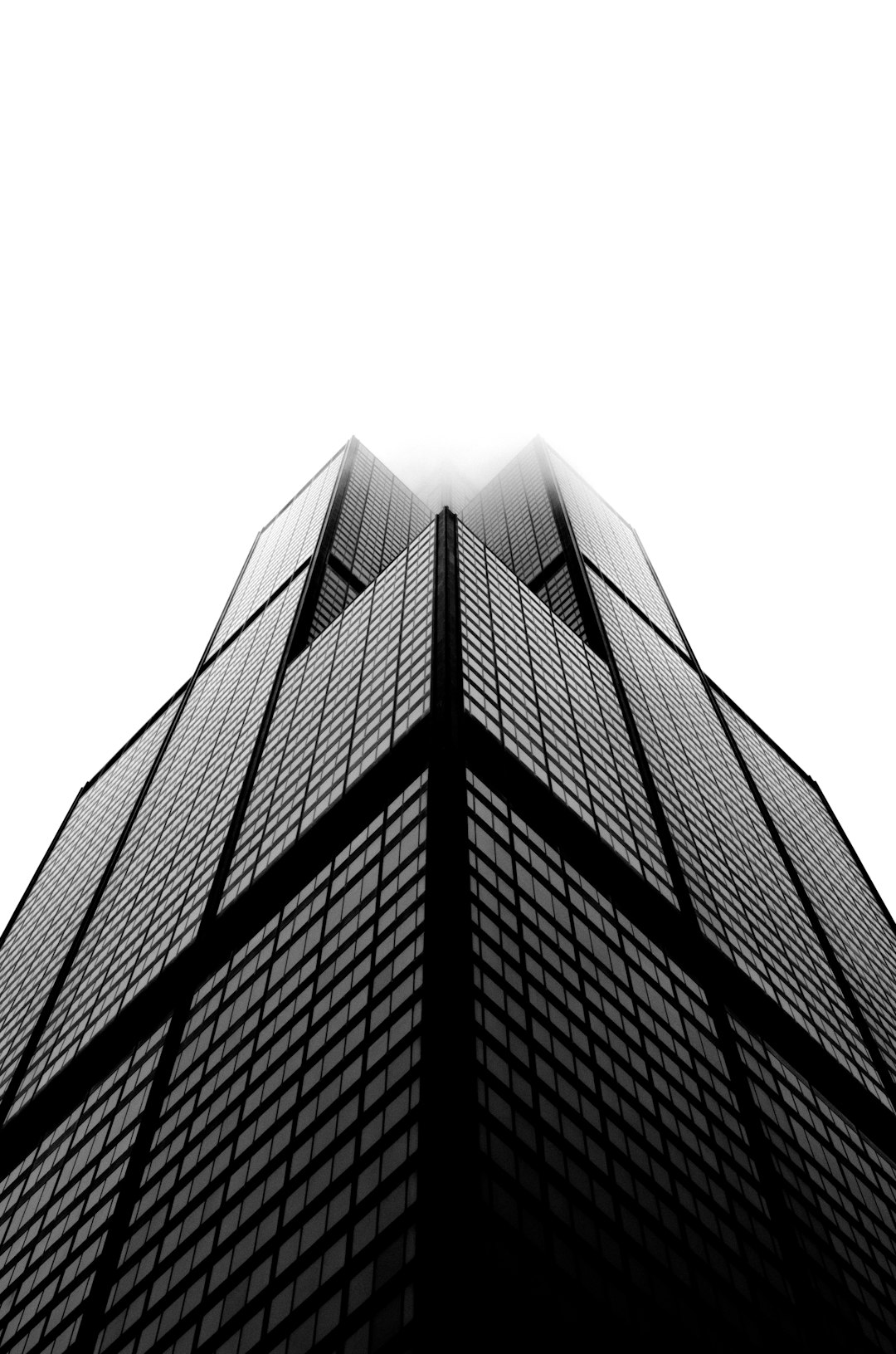 Black and white photo of the John Hancock shaped skyscraper in Chicago, white background, low angle shot, foggy weather, symmetrical composition, minimalistic style, architectural photography, grainy. The photo was taken in the style of John Gokan. –ar 21:32