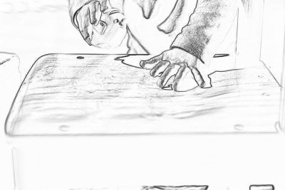 A simple black and white storyboard sketch of hands holding one side of a table while making an angled cut in wood with a circular saw, showing a closeup of hand movements and focusing on the action. The background is a clean white wall, emphasizing clarity in detailing the angles being made in the style of each movement.