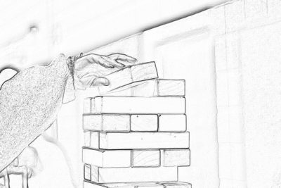 A hand is placing the last brick on top of an oversized jenga block, ready to play. The sketch is done in the style of J.EntityManager in black and white pencil style. The background shows part of another person's body wearing casual attire with their arm outstretched towards them as if they were playing together.