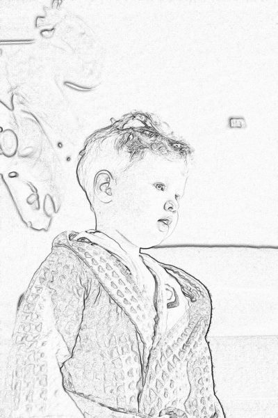 A simple sketch of an adorable little boy in pajamas, standing at the kitchen table with his head tilted to one side and looking straight ahead. The background is blurred in a neutral white or grey color tone, creating a cozy atmosphere. This drawing emphasizes facial expressions and details on  textures. It's perfect for children aged three years old who love coloring pages.