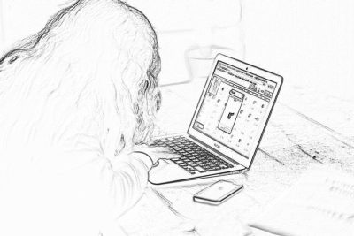 Black and white pencil sketch storyboard of a woman using a macbook laptop on a table. She is sitting in front of her computer with her head down playing a solitaire game. On top of the desk there is an iphone next to it. The focus point should be on the phone screen displaying a casual bubble tower mobile game with character animation. No background details, just lines.