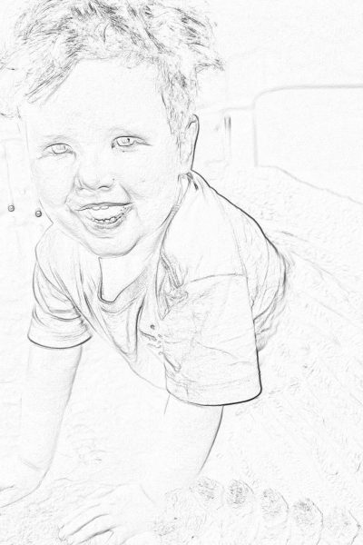 Black and white pencil sketch storyboard of young boy playing in the sand, smiling at camera