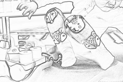 black and white line art illustration of socks with embroidered dots, hands holding the foot soles while sewing them on an ironing board, a box full of fabric swatches is visible in front of her, cartoon style children's book drawing, low detail