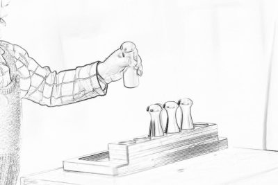 a simple pencil drawing of an arm with shirt sleeve, reaching out to place three wooden duck figures on top of the empty wood toy block in front of them. The hand is wearing plaid sleeves and has nails painted black. White background. Black ink. Simple line art.