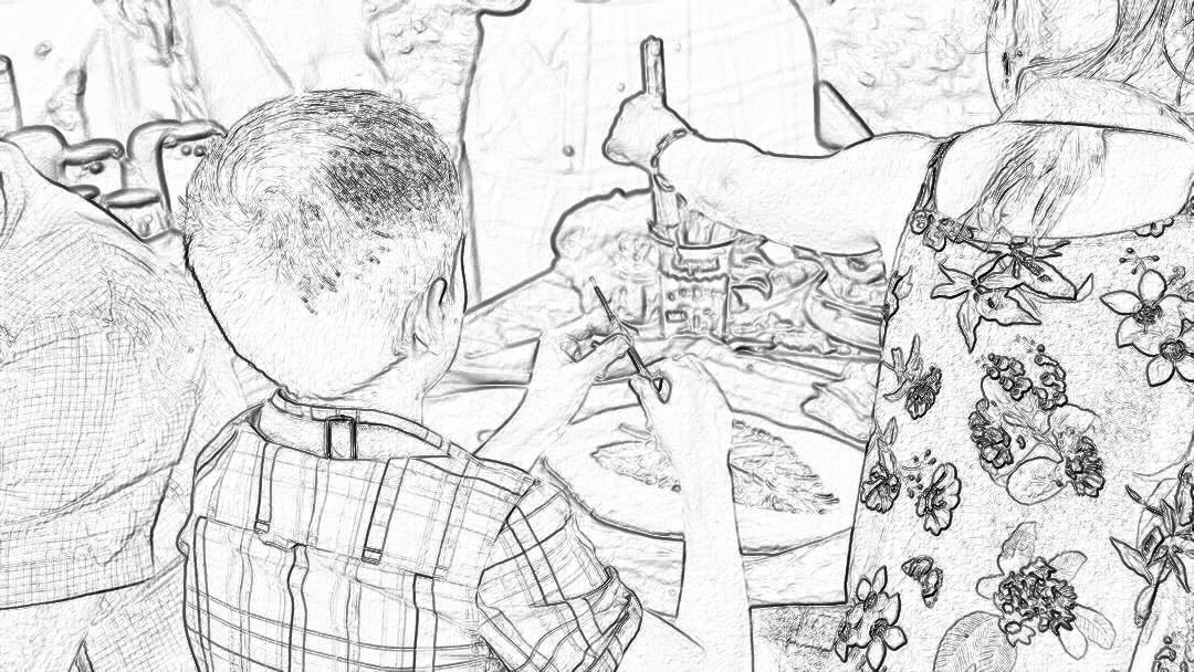 A black and white storyboard sketch of an open air family picnic in the garden, showing friends laughing around table with decorations of wildflowers and vases full of wine glasses. A young boy is sitting at one end eating chicken wings. The camera captures him from behind as he reaches for his expressionless face covered by short hair that hides half her head. He has just put on sunglasses over it. It’s sunny outside. The focus should be on their faces,