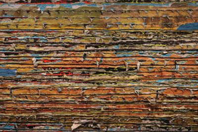 An abstract representation of an entire wall made up entirely from stacked, torn paper in various colors and sizes, creating the illusion that it is carved out of wood or stone. The layers appear to be slightly worn at their edges, adding depth and texture to the composition. This artwork would evoke feelings of nostalgia for many people as they remember reading through ripped pages in old books. It could also symbolize different life experiences layered together in the style of Siño art. --ar 128:85