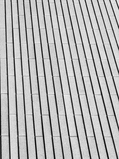 Black and white image of straight lines on the roof of grey granite pavers, textured background, simple and minimalistic style. The image is in the style of minimalism.