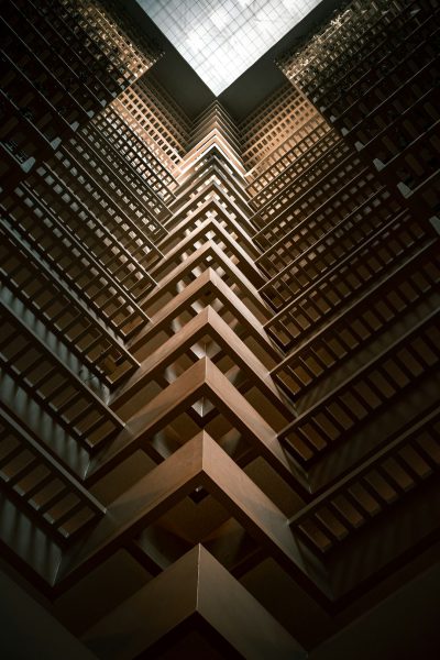 A vertical view of the interior wall and ceiling of an Art Deco skyscraper made from brown wood slats with geometric patterns, with extreme detail, cinematic lighting, shot on film, Kodak Portra400, in the style of Kodak Portra400. --ar 85:128