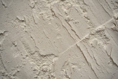 Closeup of wall texture with plaster and rough sand effect, background for interior design or decoration in gray tones. --ar 128:85