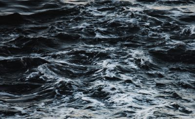 dark water, deep sea, rough waves, top view, hyper realistic photography --ar 64:39