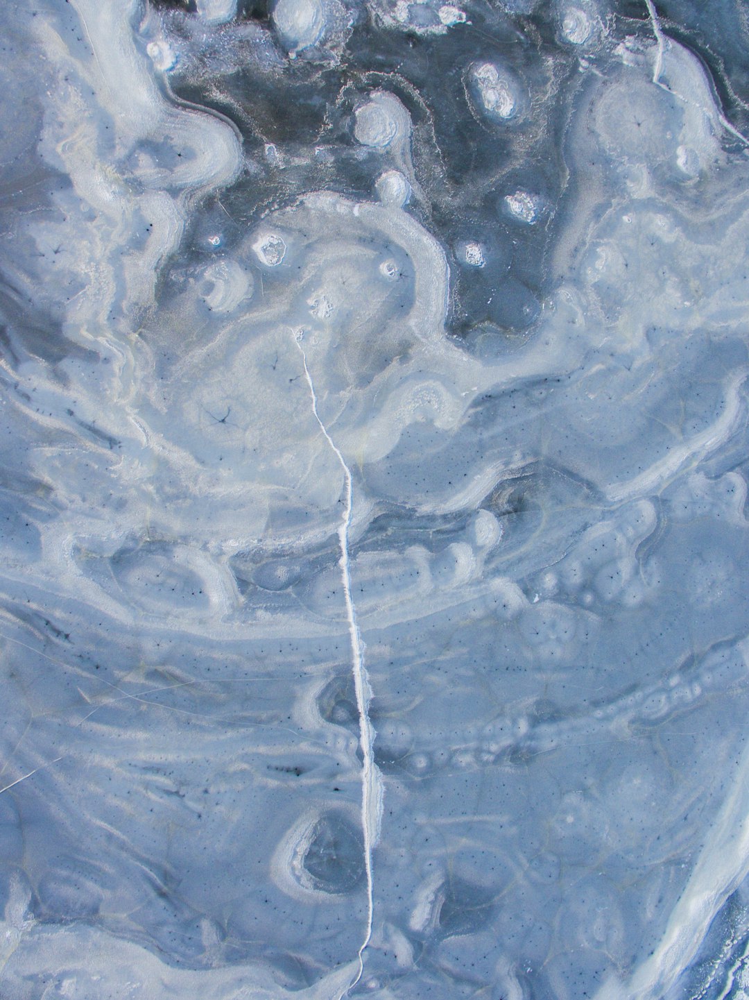 an abstract painting of swirling ice, blue and grey colors, a small white crack in the center is filled with water drops, close up, macro photography, –ar 95:128