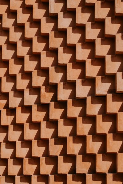 a terracotta wall made of squares with the shadows in chevron pattern --ar 85:128