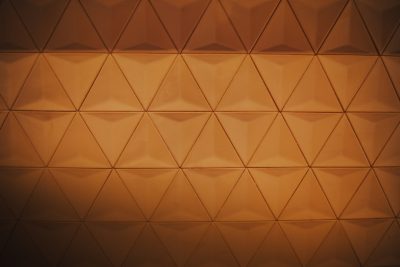 A brown wall with a triangular pattern in a low angle shot with soft lighting, high resolution photography, cinematography with cinematic light and volumetric lighting, hyperdetailed with intricate details, beautifully color graded with cinematic lighting. --ar 128:85