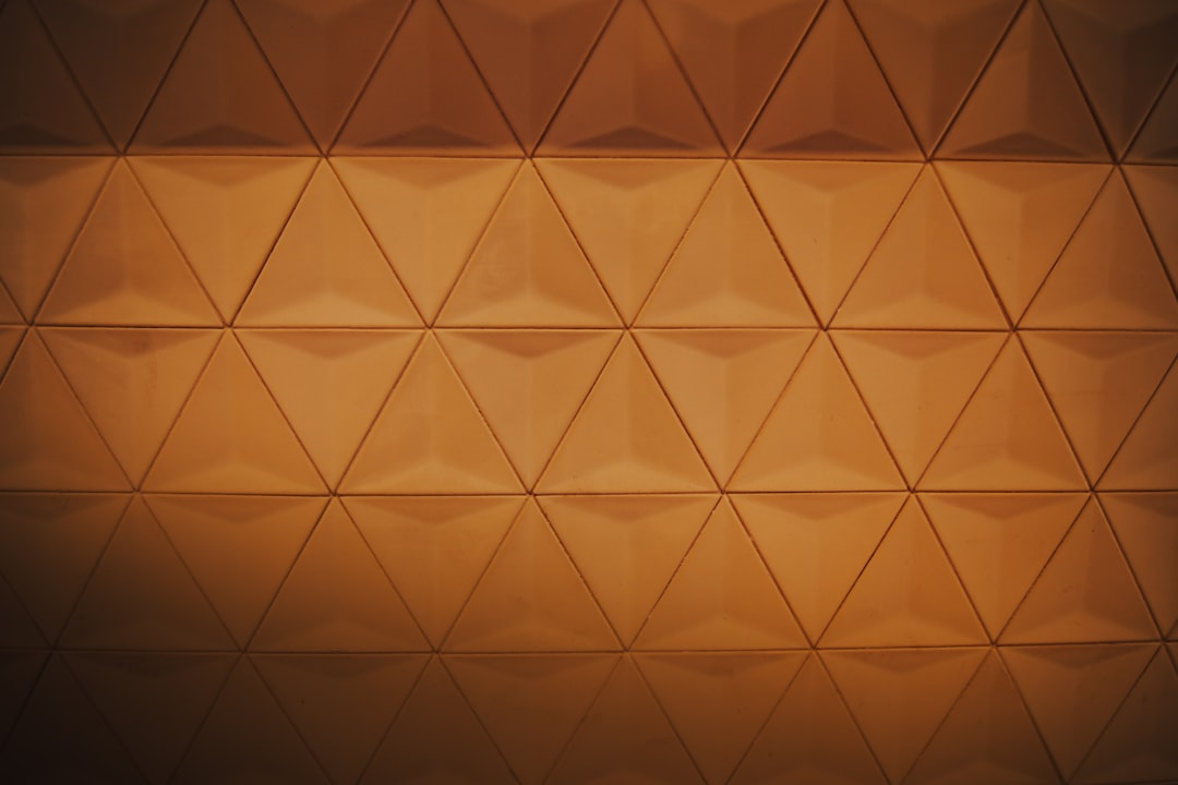 A brown wall with a triangular pattern in a low angle shot with soft lighting, high resolution photography, cinematography with cinematic light and volumetric lighting, hyperdetailed with intricate details, beautifully color graded with cinematic lighting. –ar 128:85