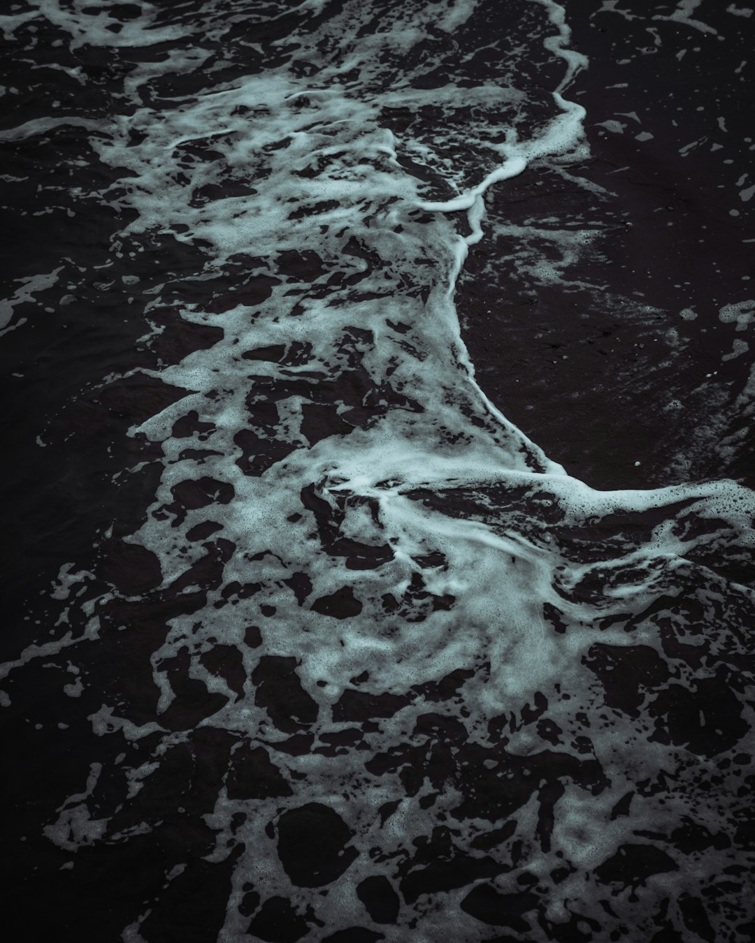 dark ocean water, dark beach, dark night, top view, aerial photography, white waves, dark atmosphere, high contrast, hyper realistic, photography, detailed, texture, –ar 51:64